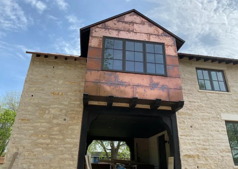 Copper metal panel facade on a stone building for Roof Repair in Harrisville